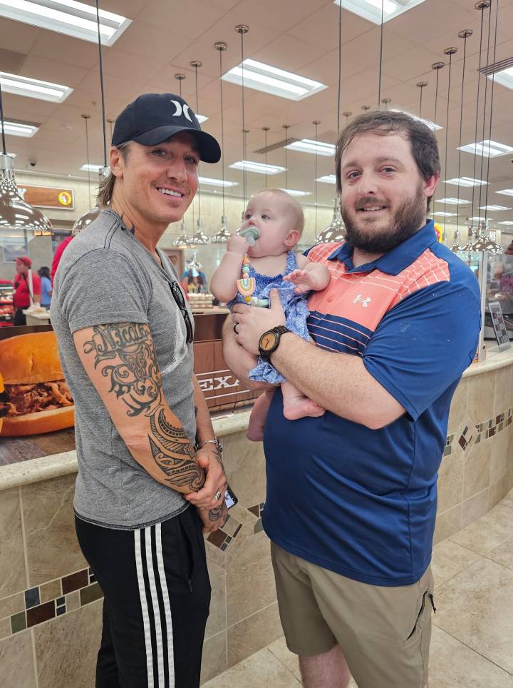Keith Urban and Tyler Clark with Clark's daughter, Emerson, at the Buc-ee's in Athens Alabama